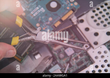 Computer service. Man repairing notebook at the table Stock Photo