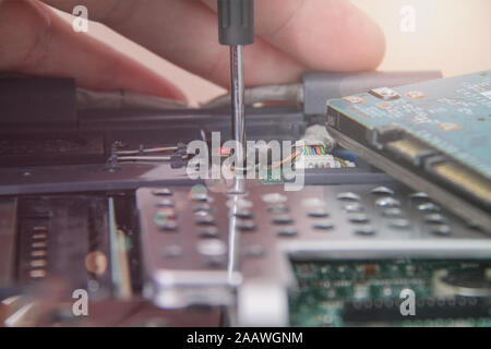 Computer service. Man repairing notebook at the table Stock Photo