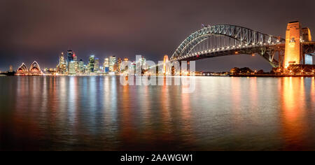 Panoramic shot of illuminated Sydney Harbor Bridge over river against sky at night, Sydney, Australia