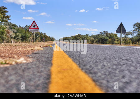 Surface level of warthog crossing sign by road against sky, Mpumalanga, South Africa Stock Photo