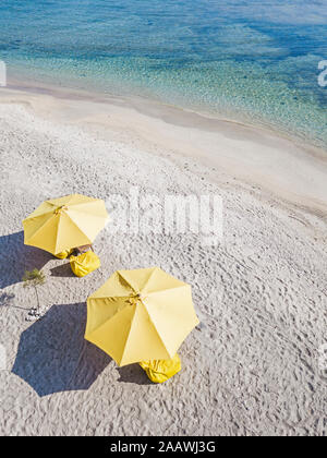 Drone shot of yellow parasols at beach during sunny day, Gili-Air Island, Indonesia Stock Photo