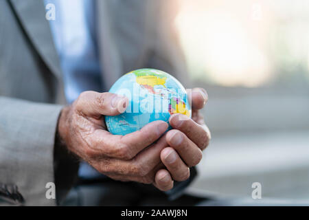 Close-up of hands of businessman holding globe Stock Photo