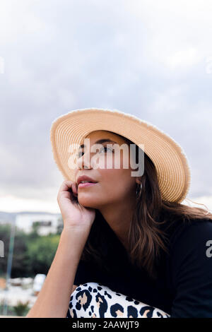Portrait of fashionable young woman daydreaming outdoors Stock Photo