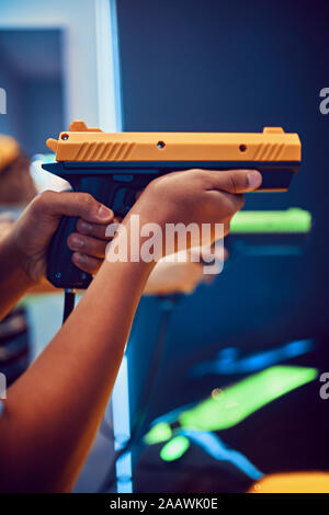 Hand of teenage boy shooting with pistol in an amusement arcade Stock Photo
