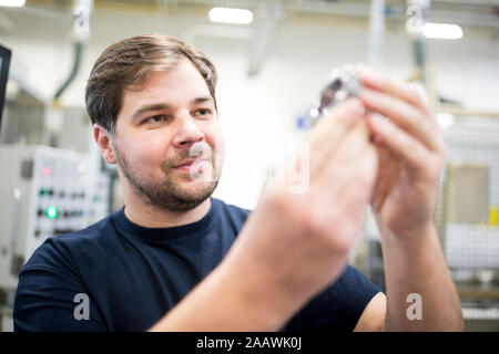 Man examining workpiece in a factory Stock Photo