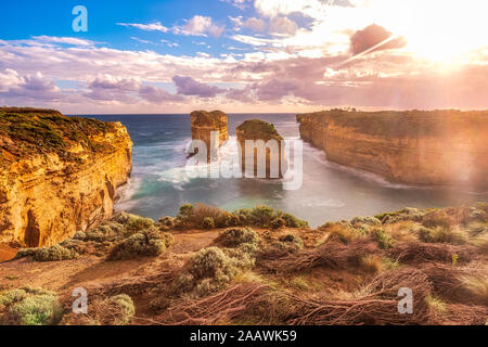 Stack rocks in sea at Loch Ard Gorge against sky during sunny day, Victoria, Australia Stock Photo