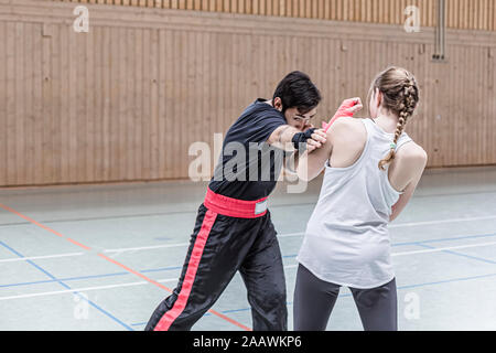 Female boxer sparring with coach in sports hall Stock Photo