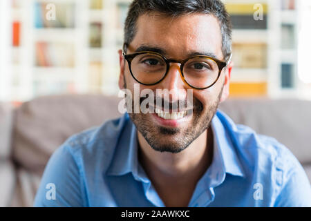 Portrait of happy young man wearing glasses  at home Stock Photo