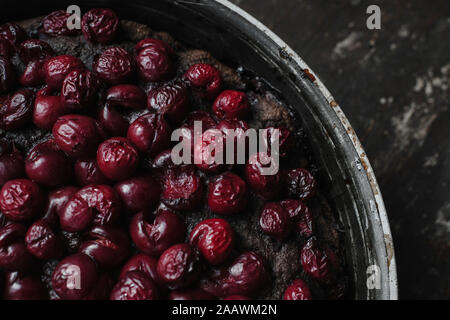 Close-up of brownie pie garnished with cherries in container on table Stock Photo