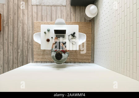 Man sitting at table working on graphics tablet and laptop, top view Stock Photo