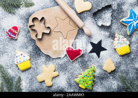 Flat lay of making Christmas cookies concept made of sugar, cutters, dough, rolling pin and fir tree branches on table. Stock Photo