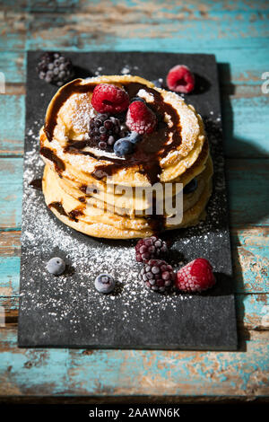Pancakes with chocolate sauce and various berries on table Stock Photo