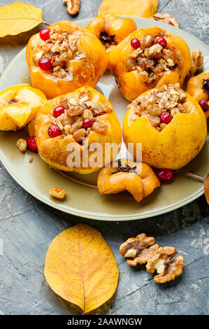 Ripe quince baked with nuts and raisins.Autumn dessert.Baked apples Stock Photo