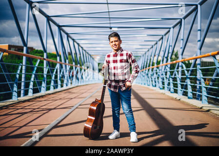 Gypsy boy with guitar on a bridge Stock Photo