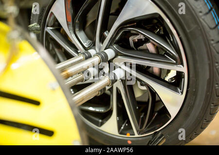 Detail of modern automatized car production in a factory, mounting of tyre Stock Photo