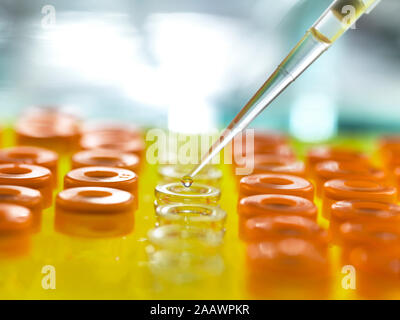 Samples being poured from pipette in vials for analytical testing at laboratory Stock Photo
