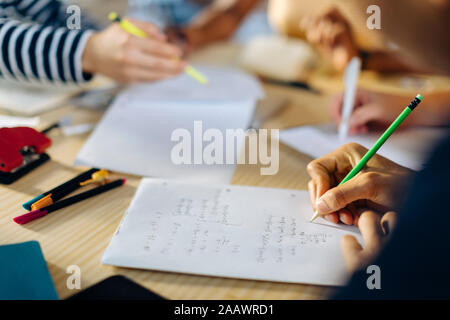Close-up of young man writing down formula Stock Photo