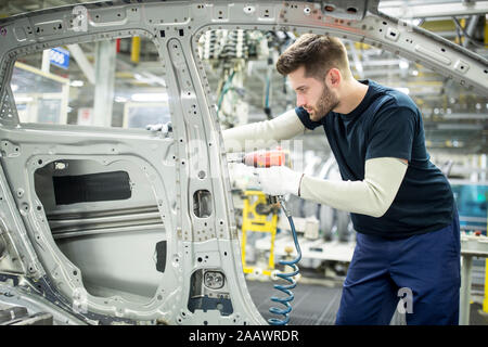Man working in modern car factory Stock Photo