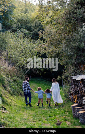 Rear view of family with two kids walking in the countryside Stock ...