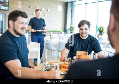 Colleagues having lunch break in canteen Stock Photo