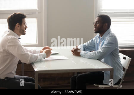 Caucasian recruiter having interview with biracial male candidate Stock Photo