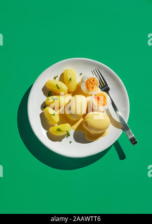 Directly above shot of healthy meal in plate with fork on green background Stock Photo