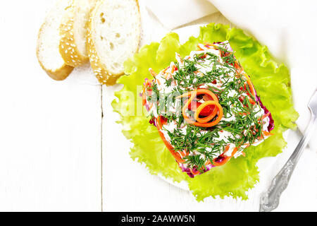 Puff salad with beef, boiled potatoes and beets, pears, spicy Korean carrots, seasoned with mayonnaise and garnished with dill on a green lettuce in a Stock Photo