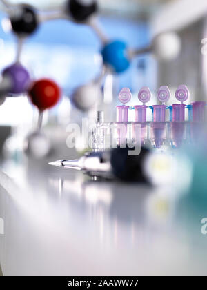 Close-up of pipette with molecular structure and test tubes on table in laboratory Stock Photo