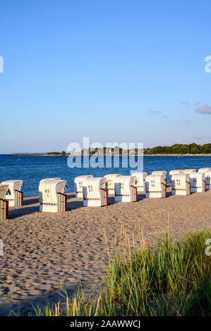 Germany, Schleswig-Holstein, Niendorf, Strandkorb beach-chairs on sandy coastal beach Stock Photo