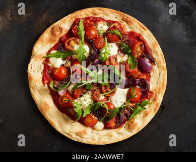 Close-up of pizza with tomatoes, onions, mozzarella and basil Stock Photo