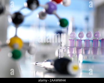 Close-up of test tubes with pipette and molecular structure on table in laboratory Stock Photo