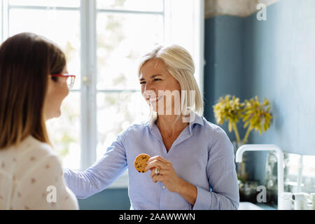 Colleagues taking a break, eating cookies Stock Photo