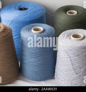 Dark Multi-colored bobbins of wool yarn for hand and machine knitting Stock Photo