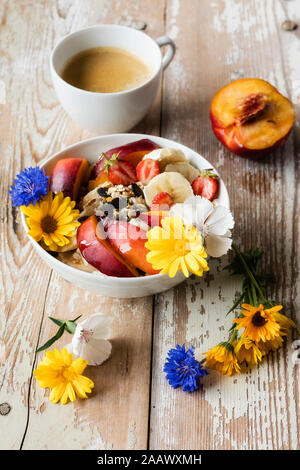 High angle view of food and drink with flowers on wooden table