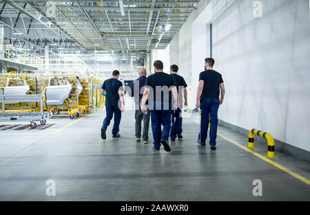 Colleagues having a break and walking in a modern car factory Stock Photo