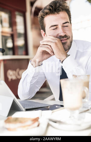 Young businessman having a break at a cafe in the city, Lisbon, Portugal Stock Photo