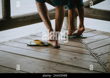 two pair of legs wearing brazilian flipflops / sandals Stock Photo