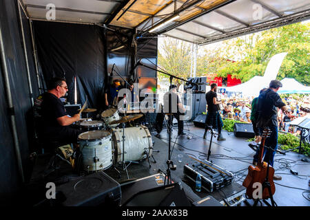 Faversham Hop Festival. Back of stage view of the French rock band 'Sur Les Docks' playing a concert in front of a packed crowd during a sunny day. Stock Photo