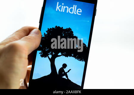 A smartphone with the Kindle app on it. Stock Photo