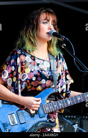 French singer songwriter, Estelle Mey performing at the Faversham Hop Festival. Young woman playing electric guitar and singing into microphone. Stock Photo