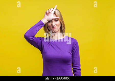 Portrait of displeased young woman in elegant tight purple dress standing with hand on forehead showing loser gesture, unemployed or fired from job. i Stock Photo