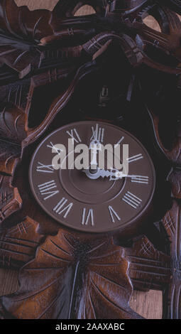 Cuckoo clock hanging on a rustic wooden wall Stock Photo