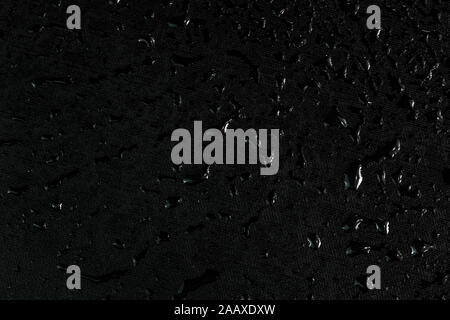 black flat rubber surface with water drops macro background. Stock Photo