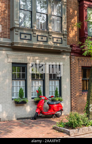 A vibrant red Vespa scooter parked outside a row house in South 4th Street, Society Hill. Stock Photo
