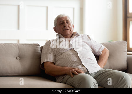 Unhealthy older man suffering from strong pain in back. Stock Photo