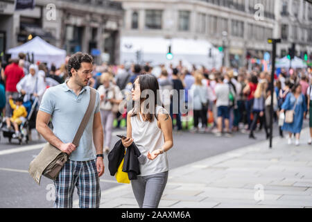 London, UK, July 14, 2019. Conversation between two people in crowded Street London. Selected focus Stock Photo