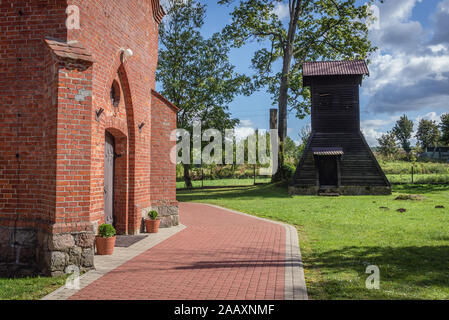 Wooden bell tower next to Roman Catholic church Nativity of the Blessed Virgin Mary in Glaznoty village located Ostroda County of Poland Stock Photo