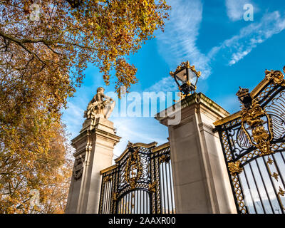 Autumn scene with gothic style gate and golden fence against the blue sky in front of the famous Buckingham Palace of London Stock Photo
