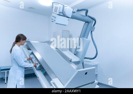 Woman doctor preparing X-ray machine for using Stock Photo