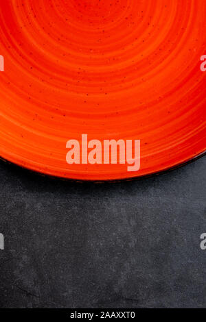 empty red plates on black stone background Stock Photo